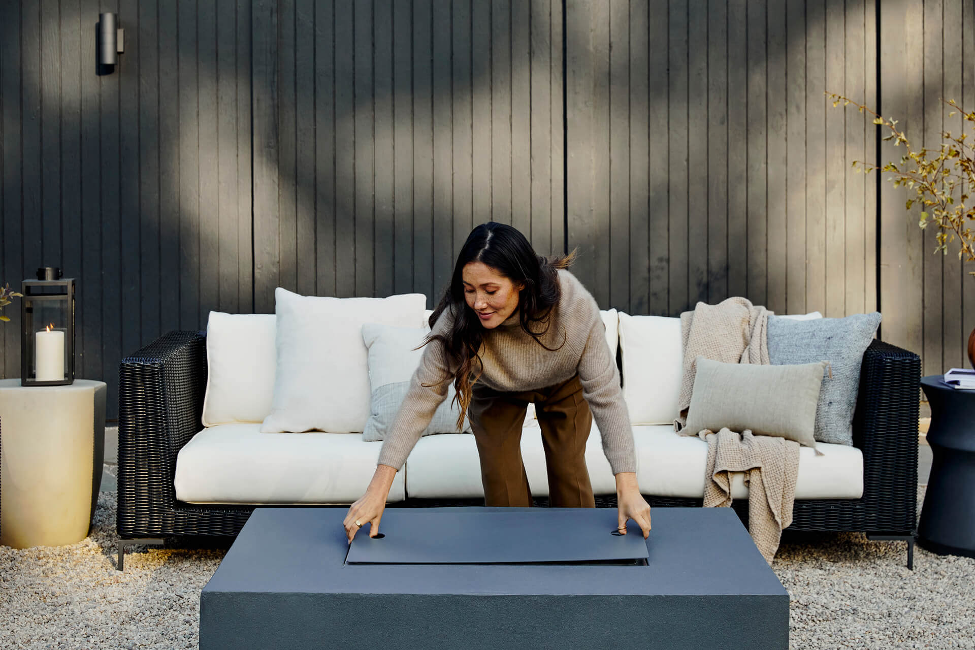 Fire pit table burning with ceramic spheres around the stainless steel burner pan