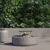 Round concrete fire pit table on a patio beside its cylindrical propane tank cover