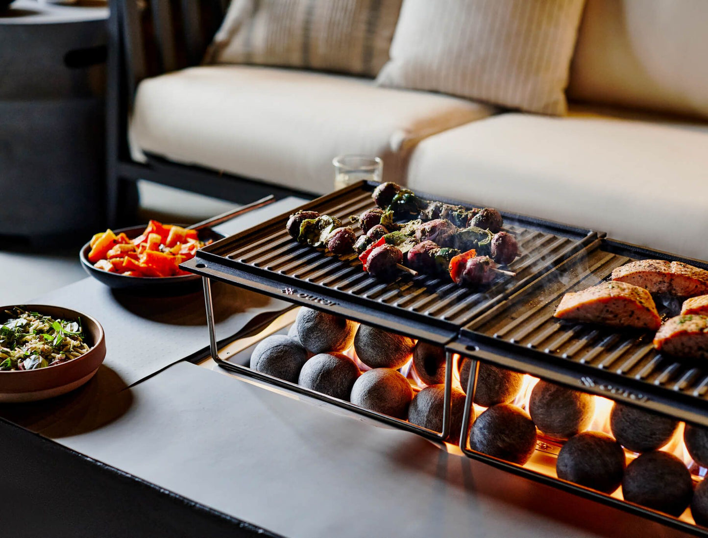 Food cooking on the griddle with the splatter guard protecting the concrete tabletop