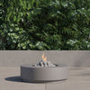 Round concrete fire pit table showing its pedestal base on a patio