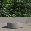 Round fire pit table with the burner cover in place, used as a low coffee table